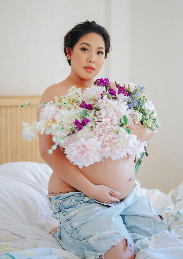 Rita Daniela poses with flowers for her maternity shoot.
