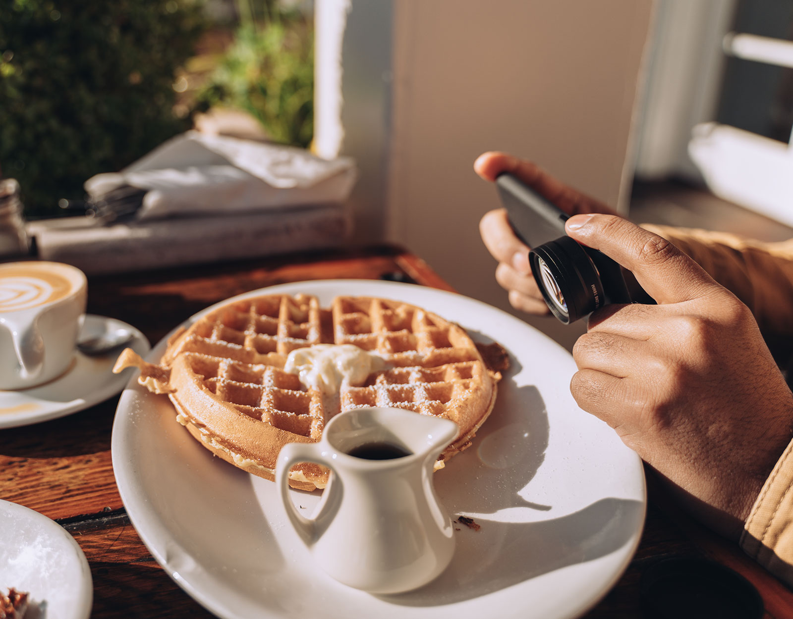 A person taking a photo of his waffle at a recommended restaurant