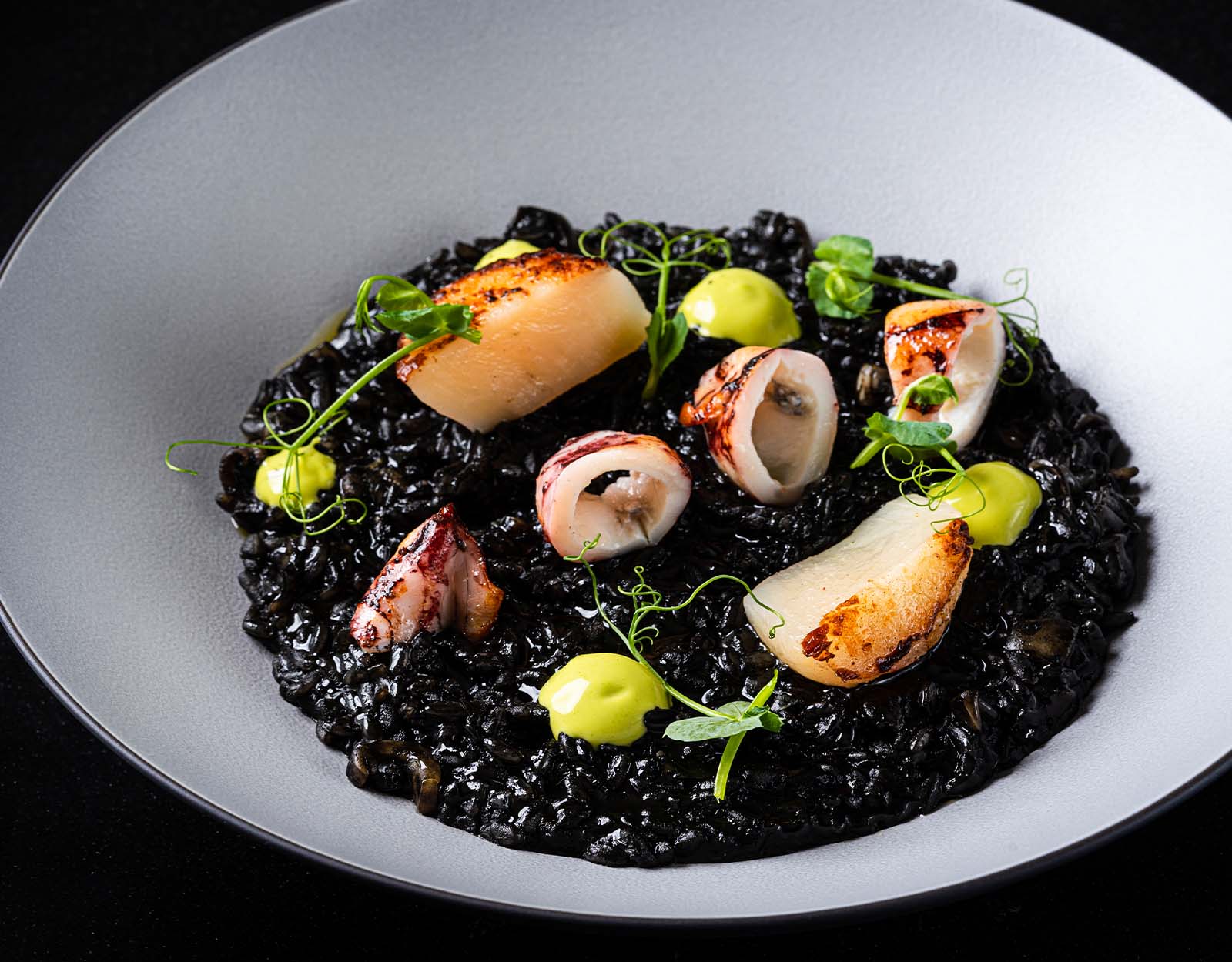 Arroz Negro de Viera y Chipiro: squid ink paella with scallops, baby squid, and herb aioli