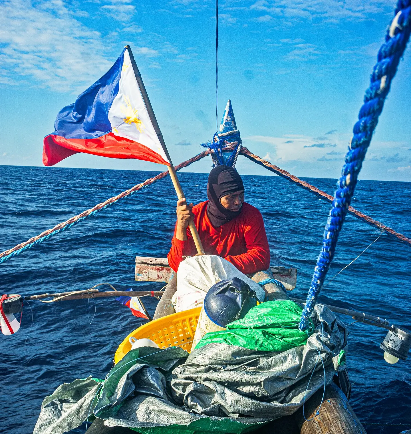 A fishermen holds the PH flag in the sea.
