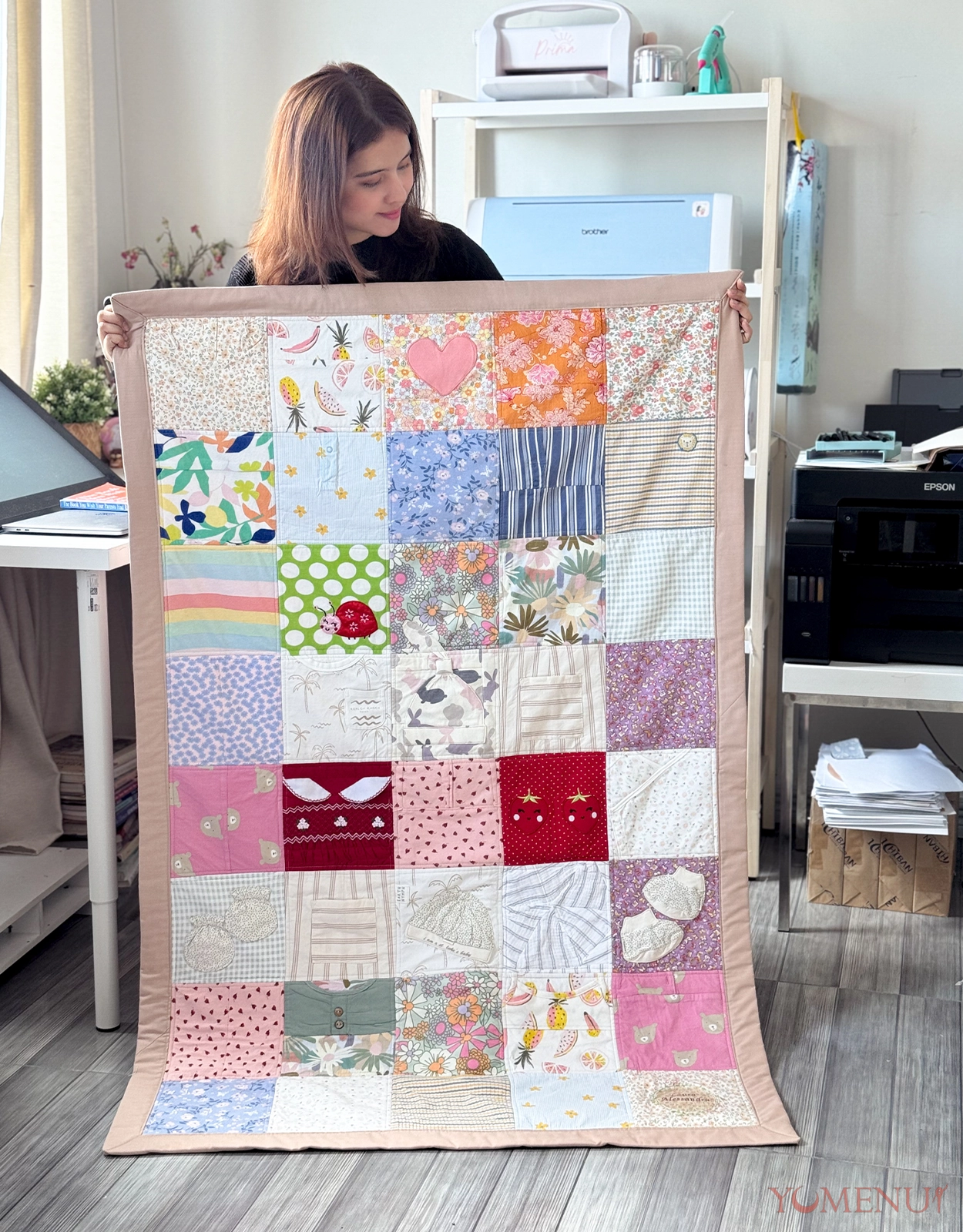 Tala Quinto and one of her outgrown baby clothes keepsake ideas—an heirloom quilt