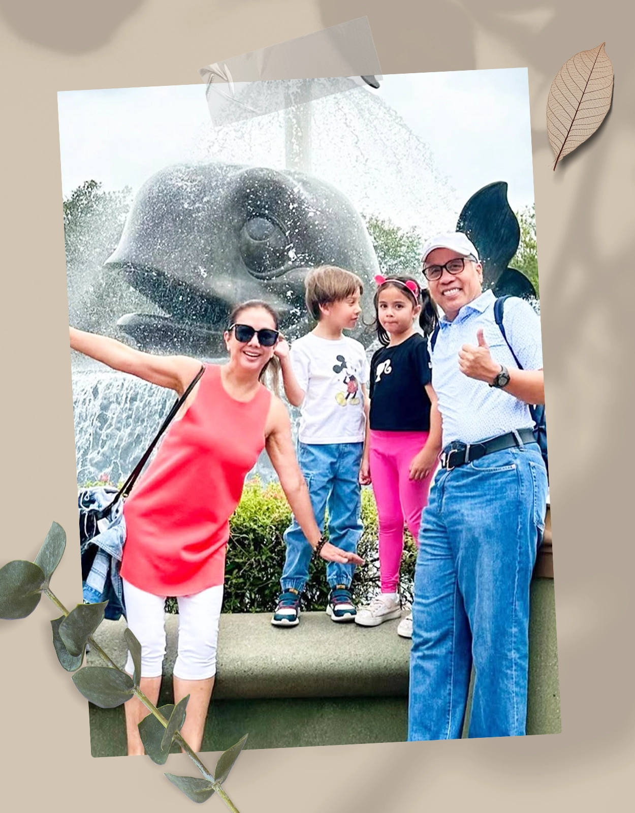 Family of five posing in front of a large whale fountain at a park, smiling for the camera.